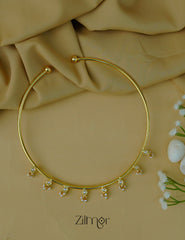 Detailed view of the pearl centerpiece on the golden Hasli neck cuff.