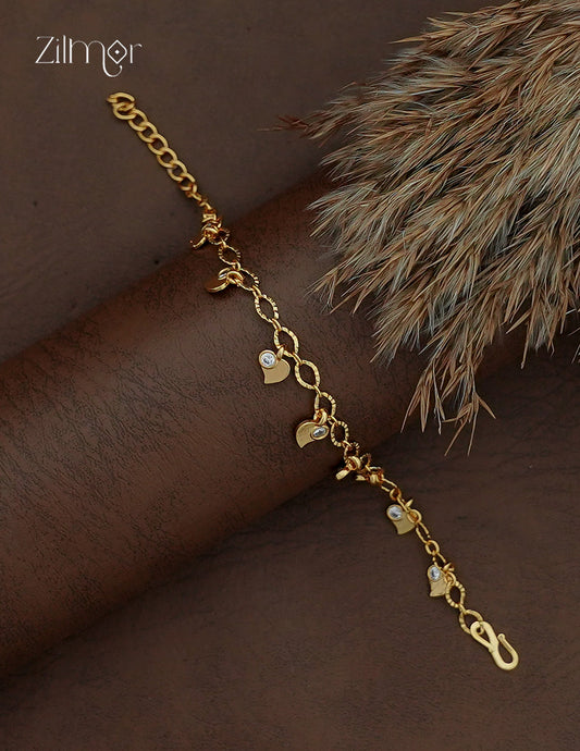 Diagonal view of Zilmor gold plated chain bracelet with dangling heart charms and AD stone accents.