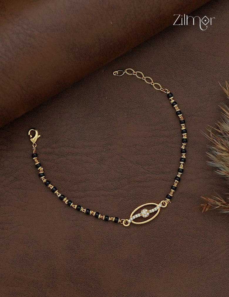 Zilmor 18K gold plated black bead mangalsutra bracelet with oval floral AD stone centrepiece and extension chain
