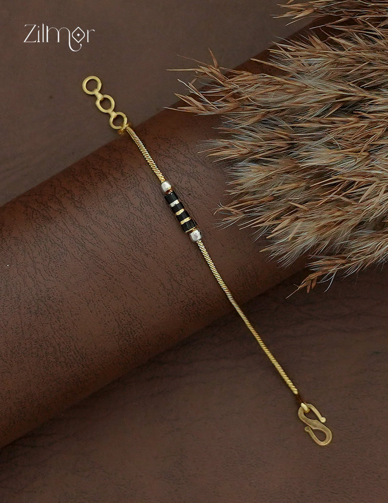 Diagonal view of Zilmor two-tone black bead bracelet showing contrasting metallic accents and hook-style clasp