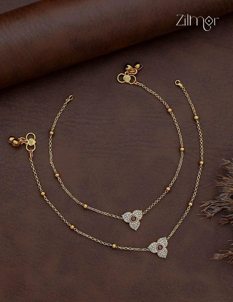 Pair of gold-tone AD stone anklets with three-petal floral motifs, ruby-colour centres and bead-accent chains