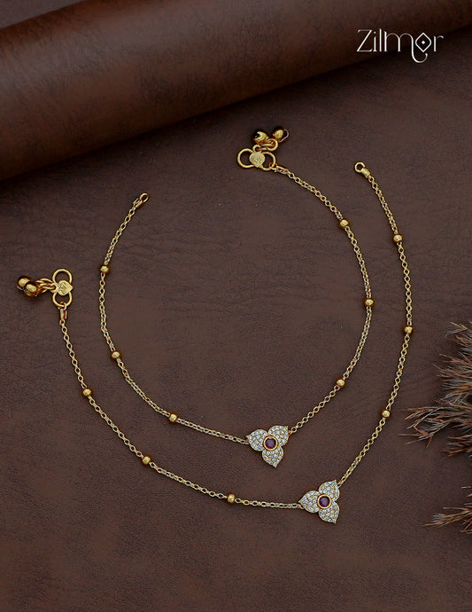 Pair of gold-tone AD stone anklets with three-petal floral motifs, ruby-colour centres and bead-accent chains