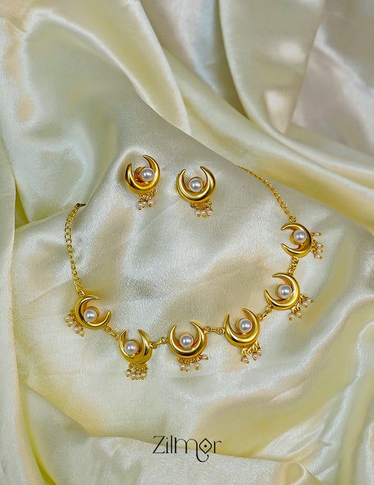 Close-up of the lustrous pearl set within the delicate gold half moon pendant.