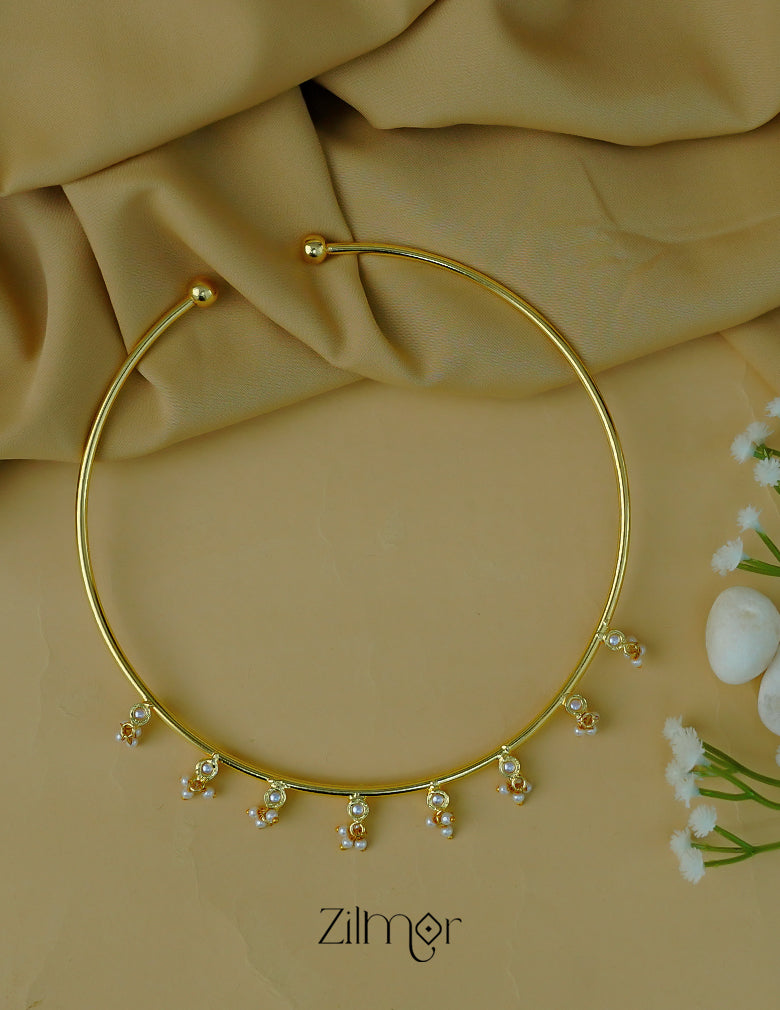 Detailed view of the pearl centerpiece on the golden Hasli neck cuff.